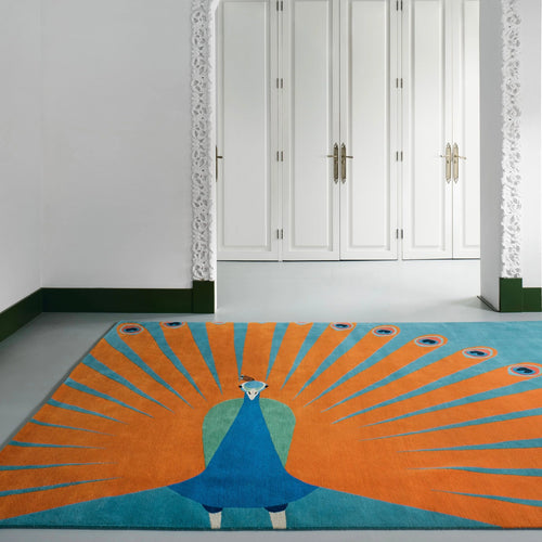 Hand tufted wool peacock rug by COZY CARPETS featuring vibrant orange fan-shaped feathers, turquoise accents, and a royal blue peacock design in an elegant modern entryway.