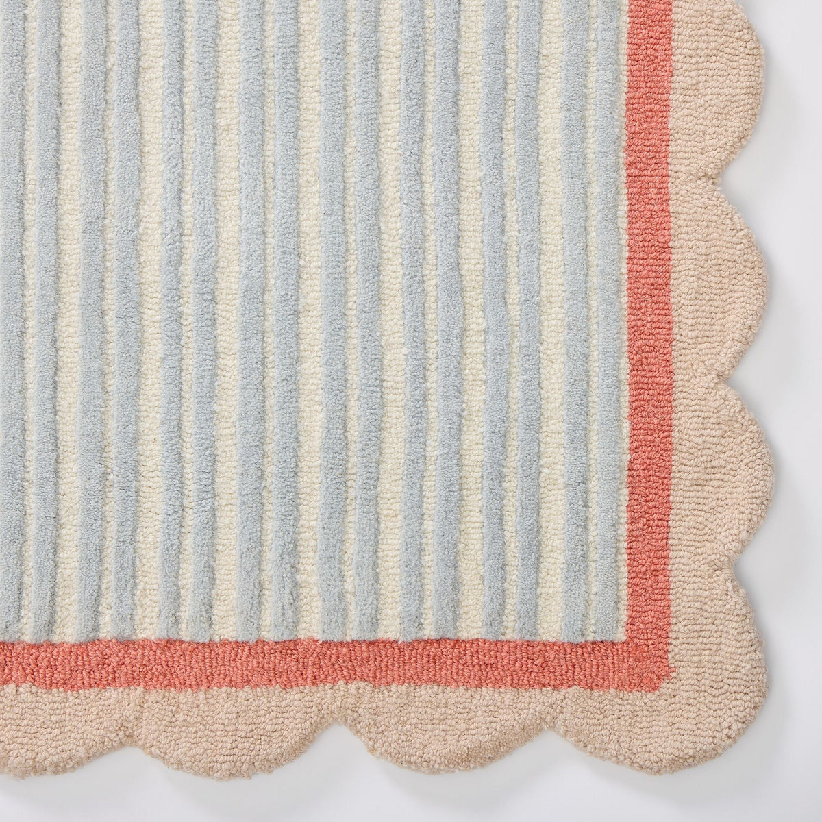 Detailed view of the textured wool pile and alternating pastel blue and ivory vertical stripes on a handmade contemporary area rug.